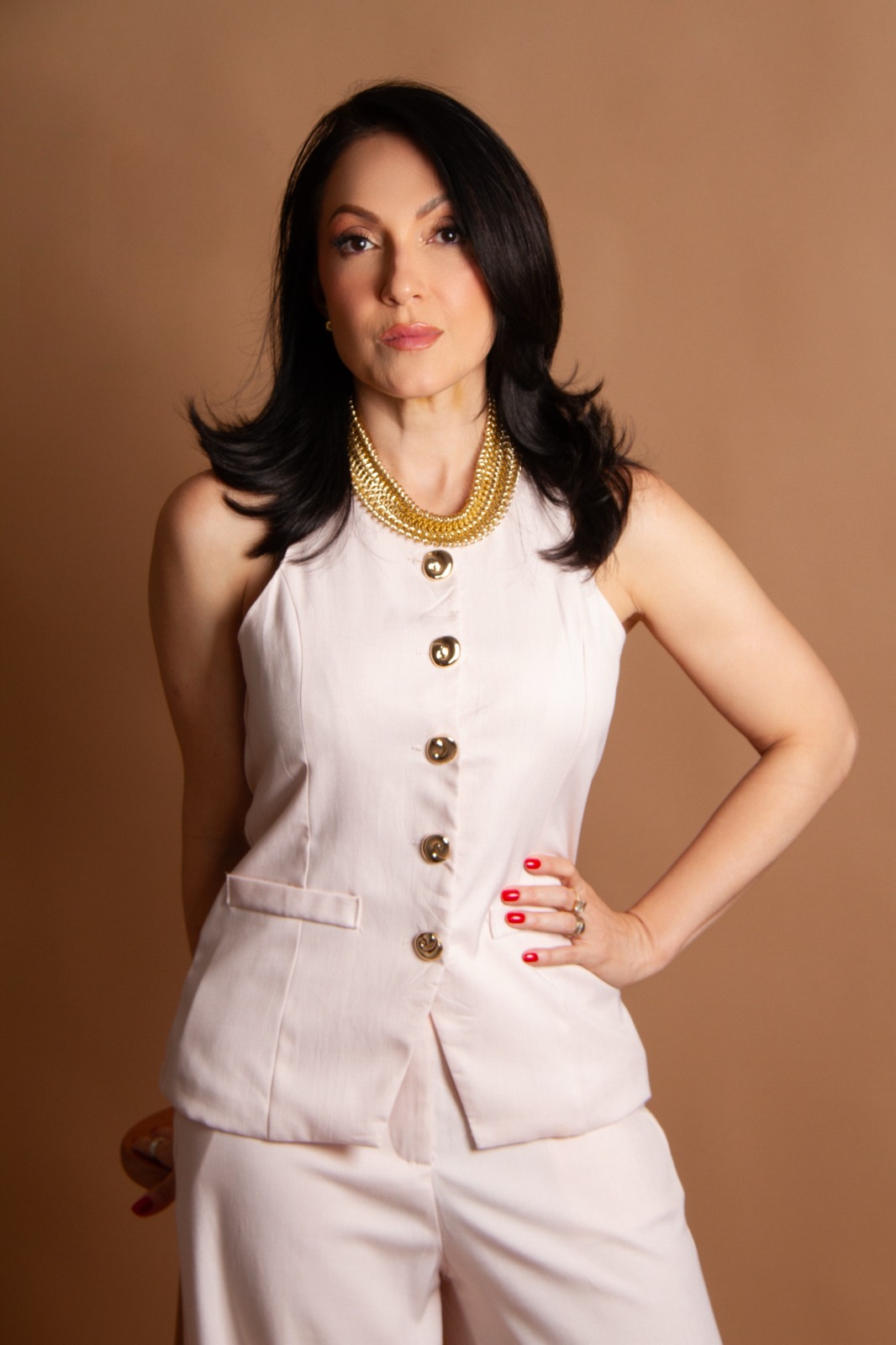 Dra. Márcia Leão em retrato de estúdio, look off-white com colar dourado